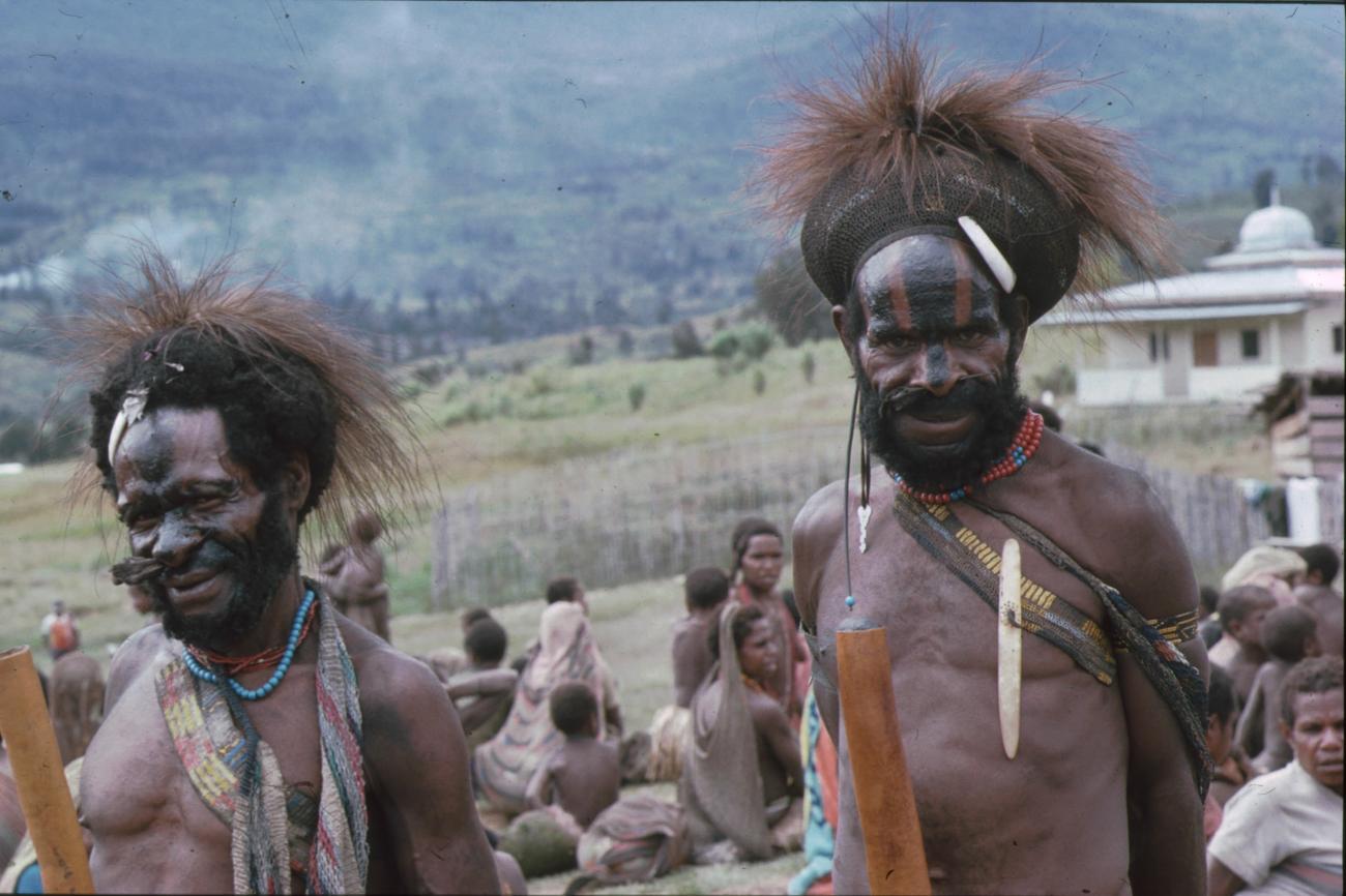 BD/166/123 - 
Twee mannen met verentooi en zwarte strepen op hun gezicht

