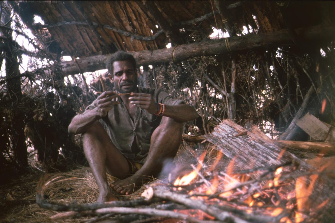 BD/166/409 - 
Papua man in shirt next to a fireplace
