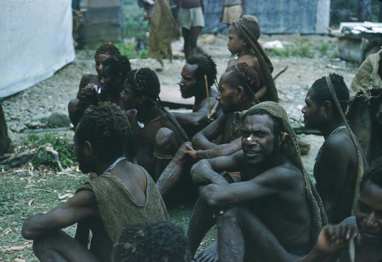 BD/209/2116 - 
Wachtende  Papoea-mannen met draagnetten
