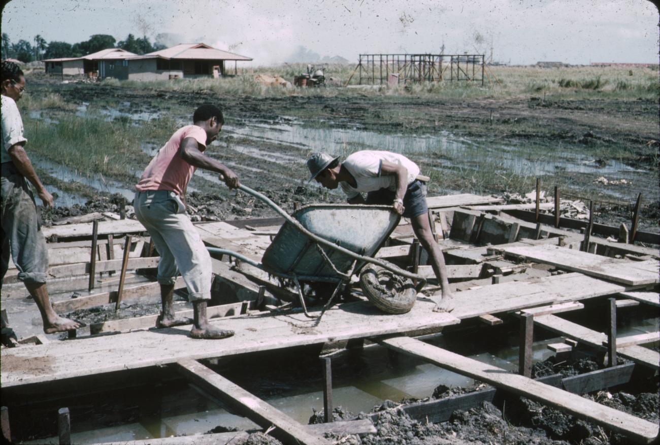 BD/288/47 - 
Mannen storten cement op bouwplaats
