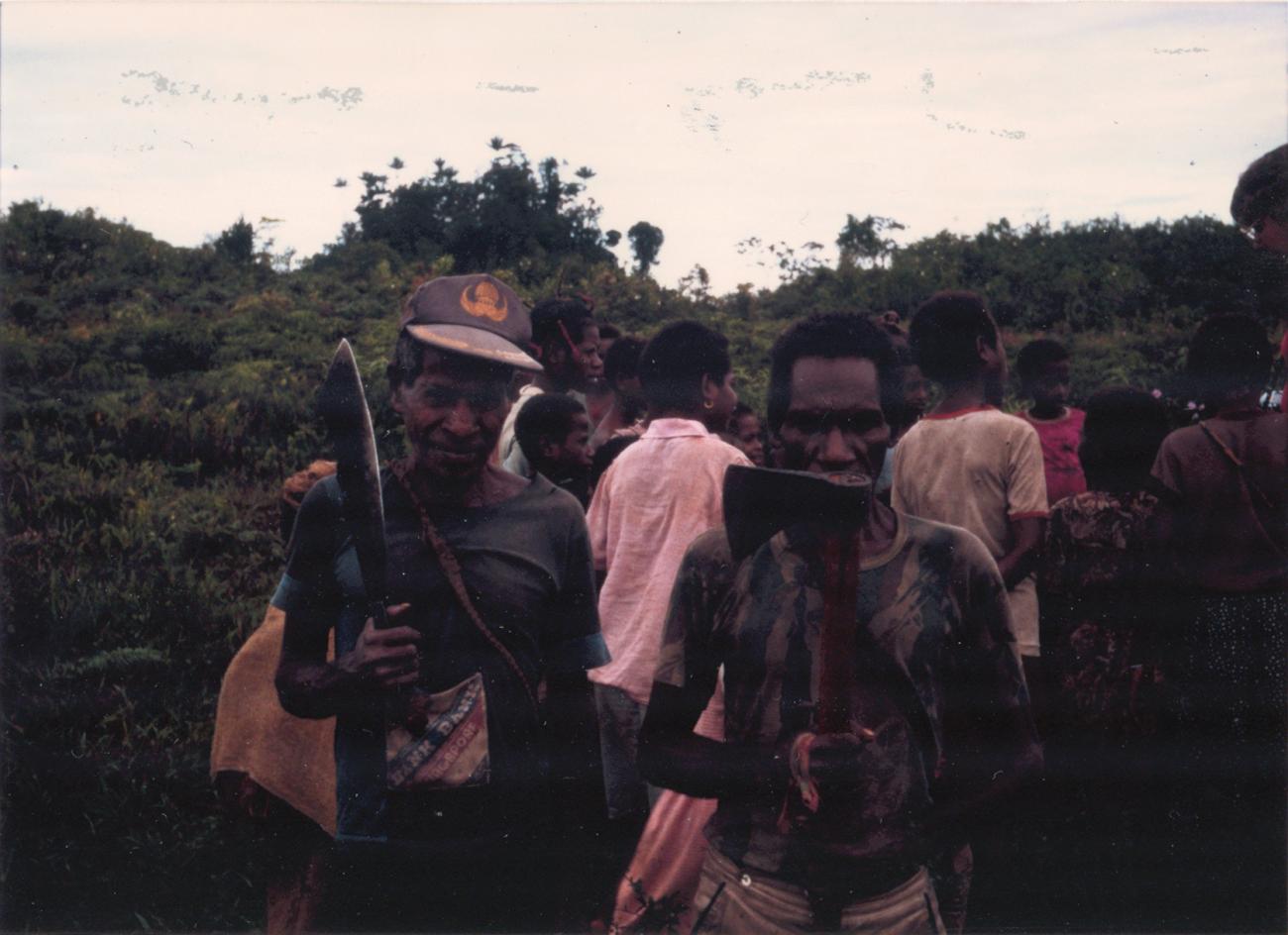 BD/309/41 - 
Dorp Mefkadjen, groepsfoto van mannen met bijl respectievelijk machete
