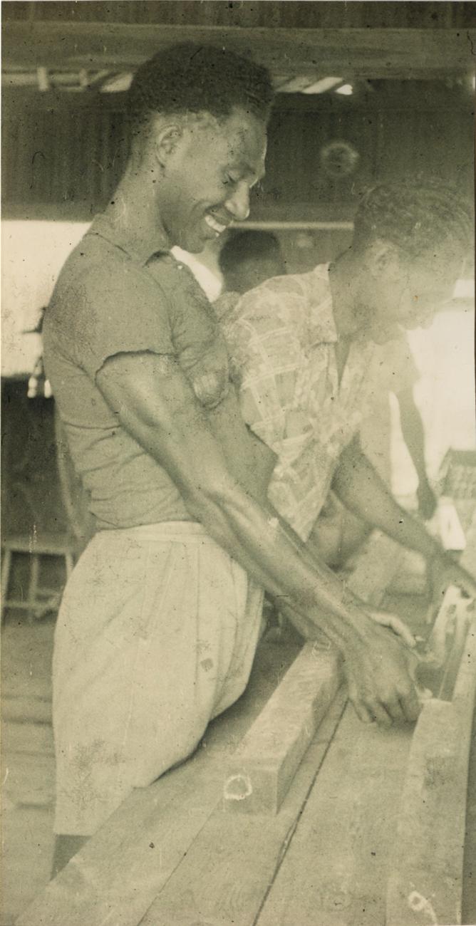 BD/309/60 - 
Dorp Teminabuan, mannen bezig met houtbewerking
