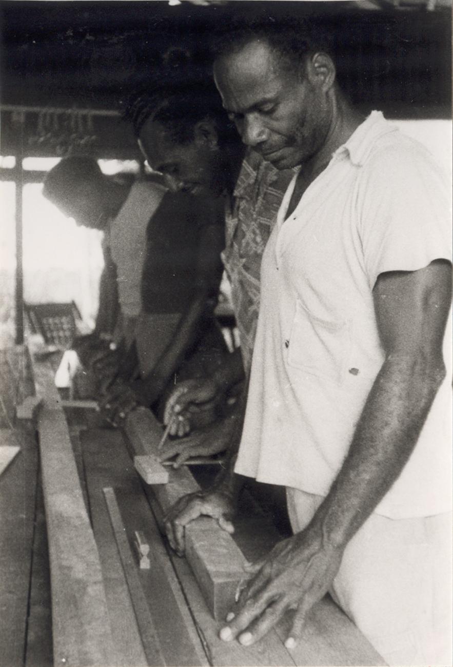 BD/309/63 - 
Dorp Teminabuan, mannen bezig met houtbewerking. Zelfde foto als 61 maar dan gespiegeld
