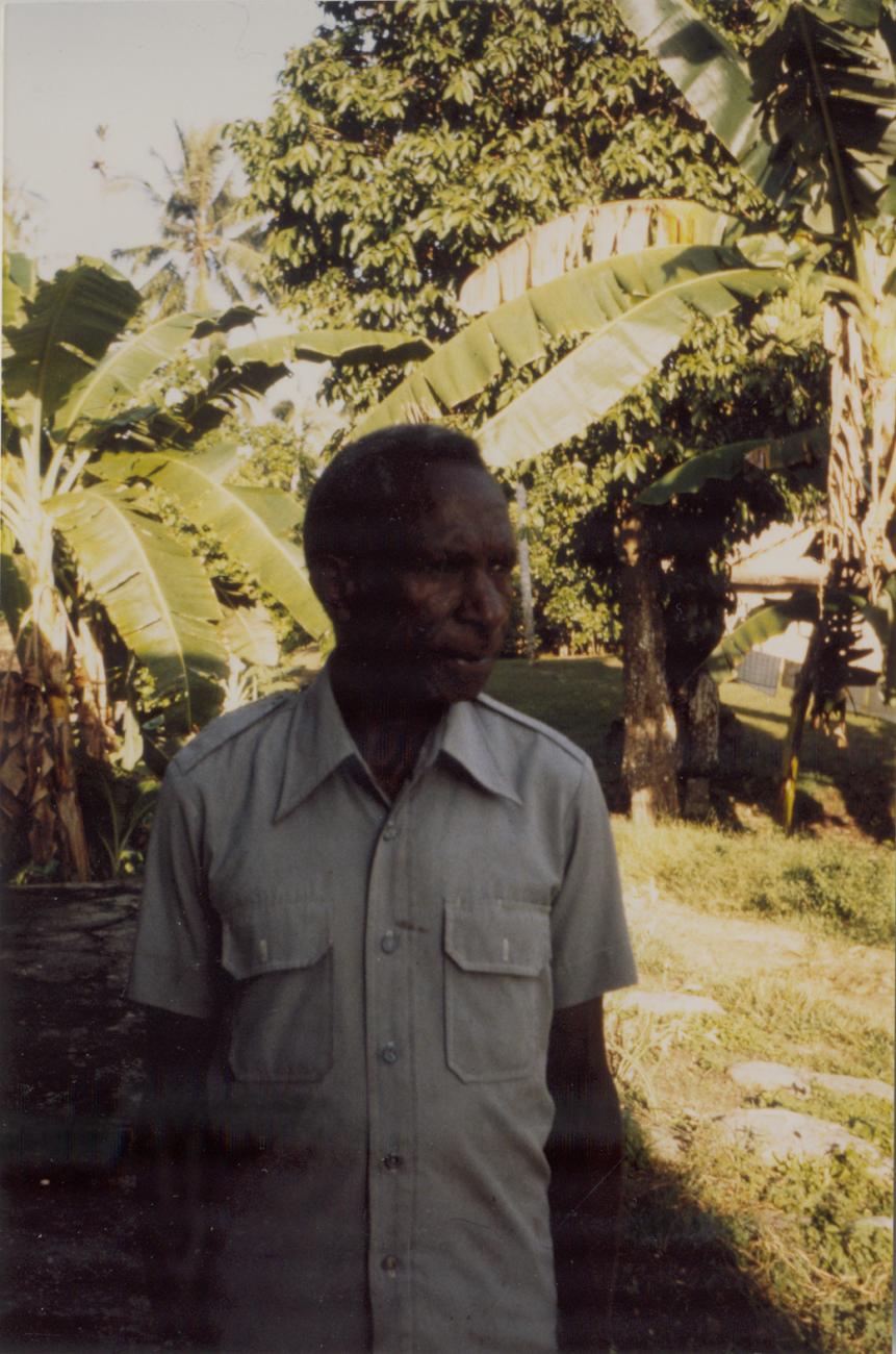 BD/309/81 - 
Dorp Bogor, portret man met op achtergrond palmen. Niet plaatsen, niet in Nieuw Guinea
