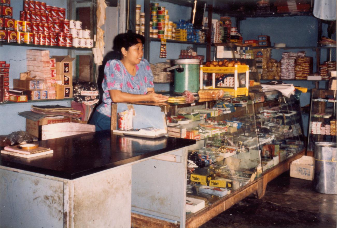 BD/309/88 - 
Dorp Bogor, vrouw achter balie winkel. Niet publiceren, niet in Nieuw Guinea
