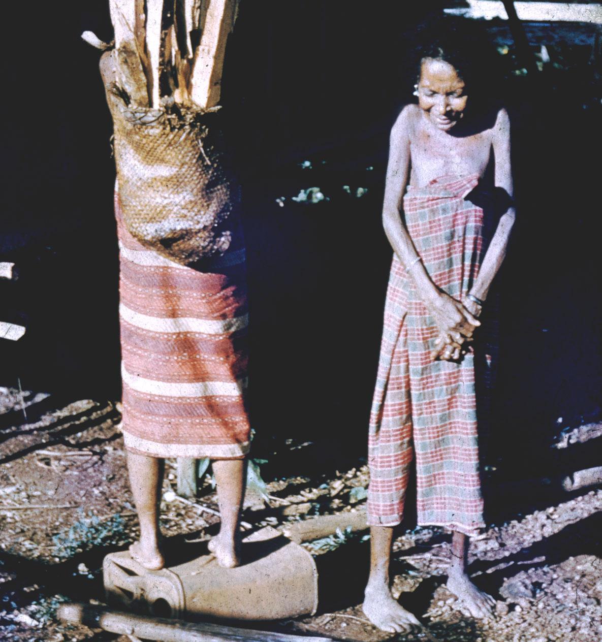 BD/144/202 - 
Geposeerde groepsfoto twee vrouwen, een met bos hout op rug
