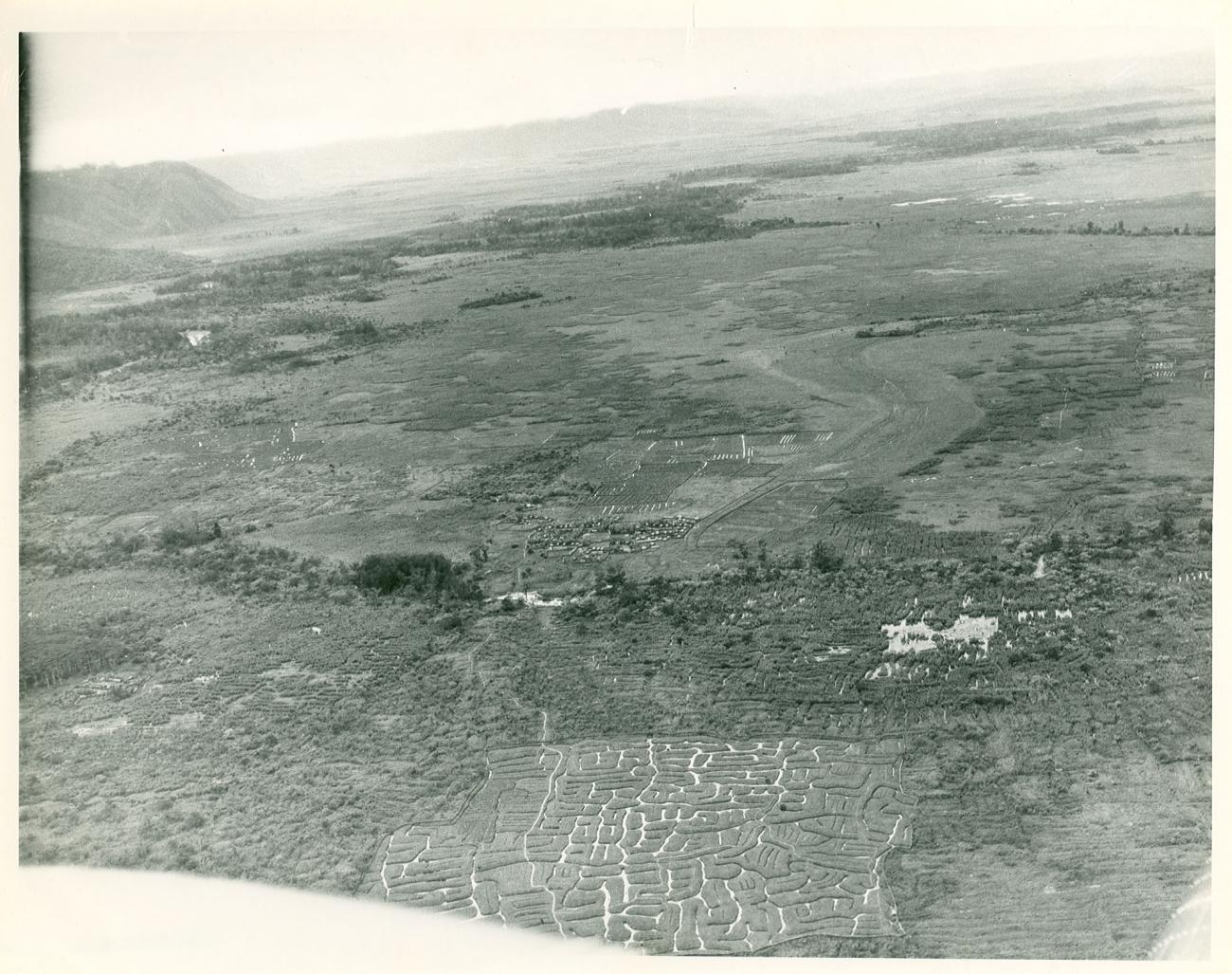 BD/23/4 - 
Luchtfoto van terrastuinen en een grote nederzetting
