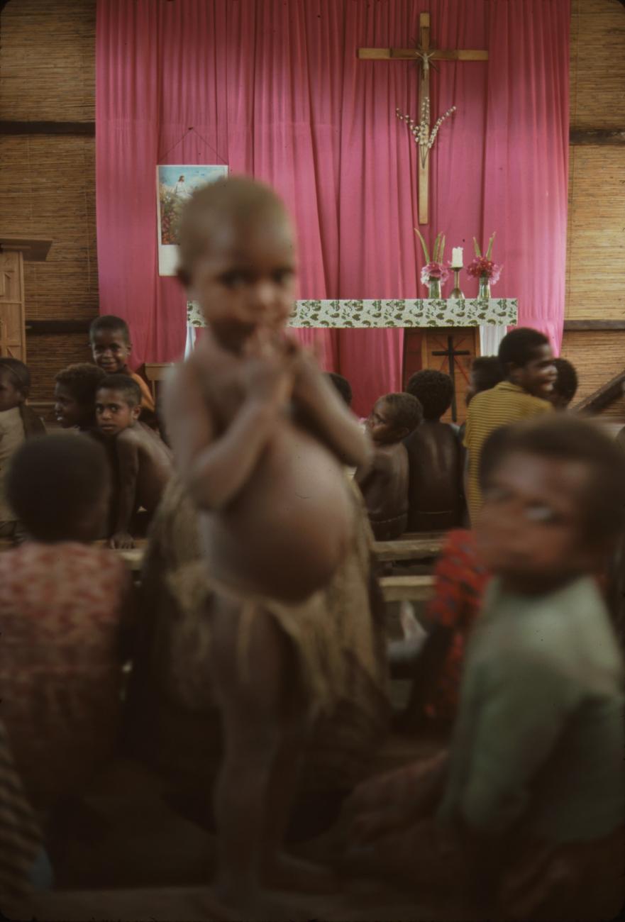 BD/132/205 - 
kind met rieten rok in de kerk
