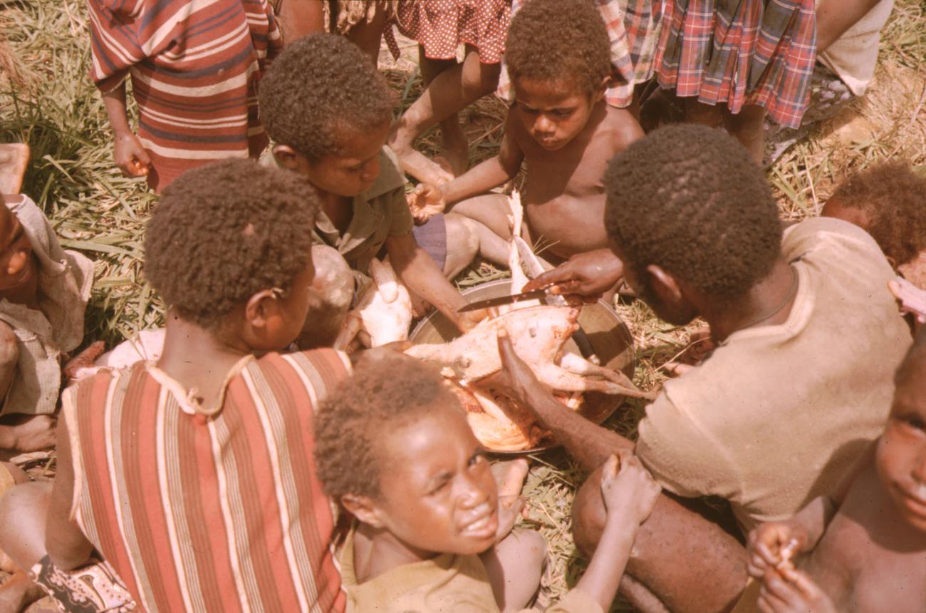BD/132/21 - 
mannen en kinderen die eten aan het voorbereiden zijn
