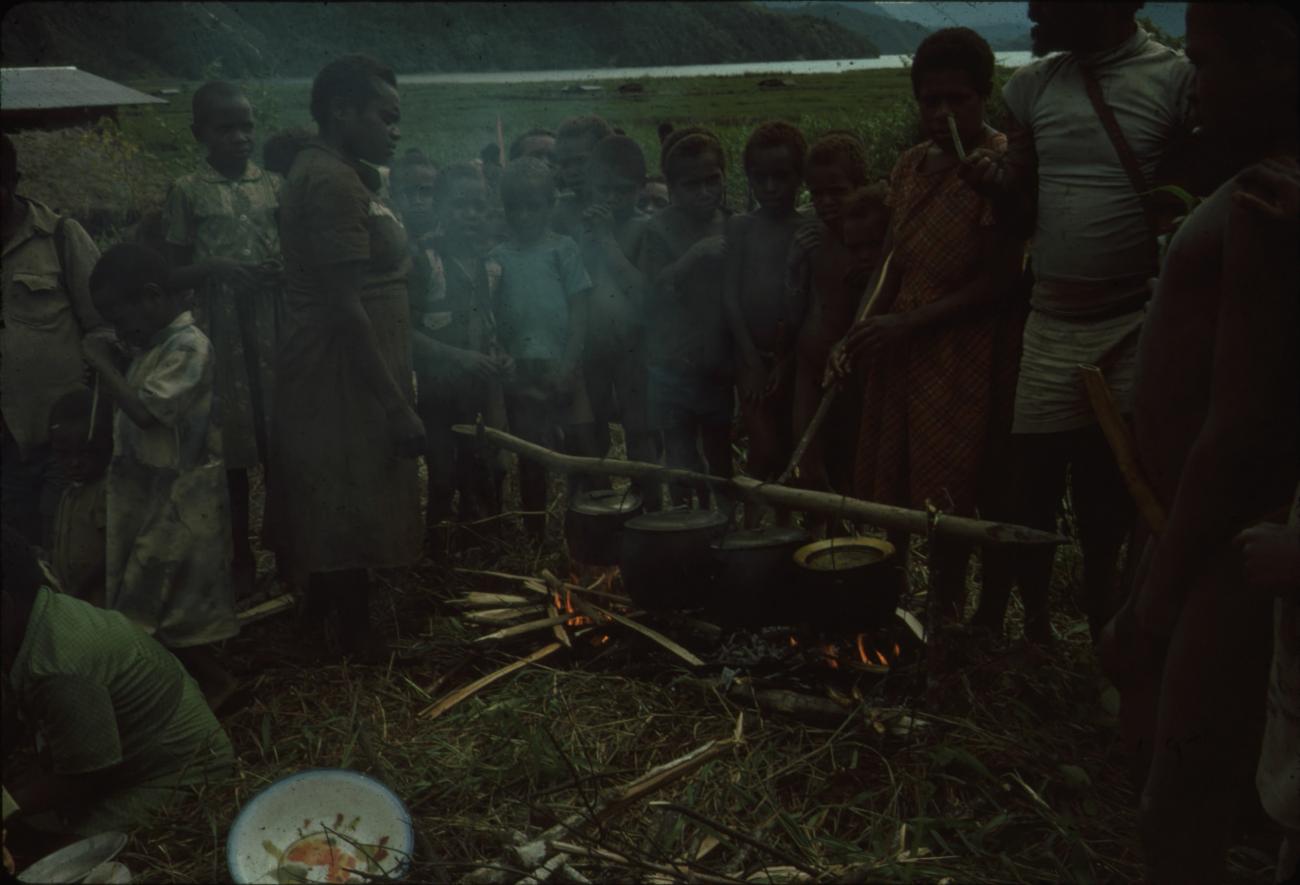 BD/132/25 - 
groepsfoto van voedselvoorbereiding door vrouw en kinderen
