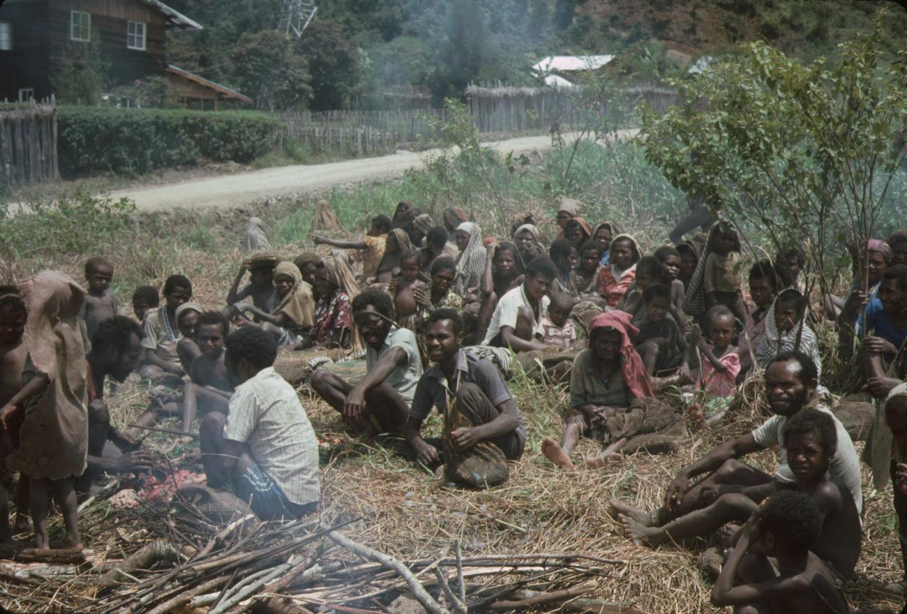 BD/132/78 - 
groep zittende mensen bij een vuur in het dorp
