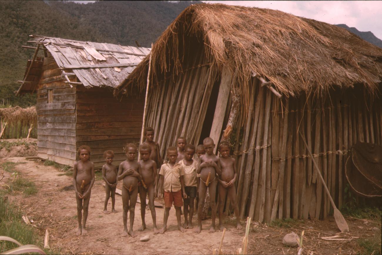 BD/132/80 - 
groep kinderen voor houten hutten
