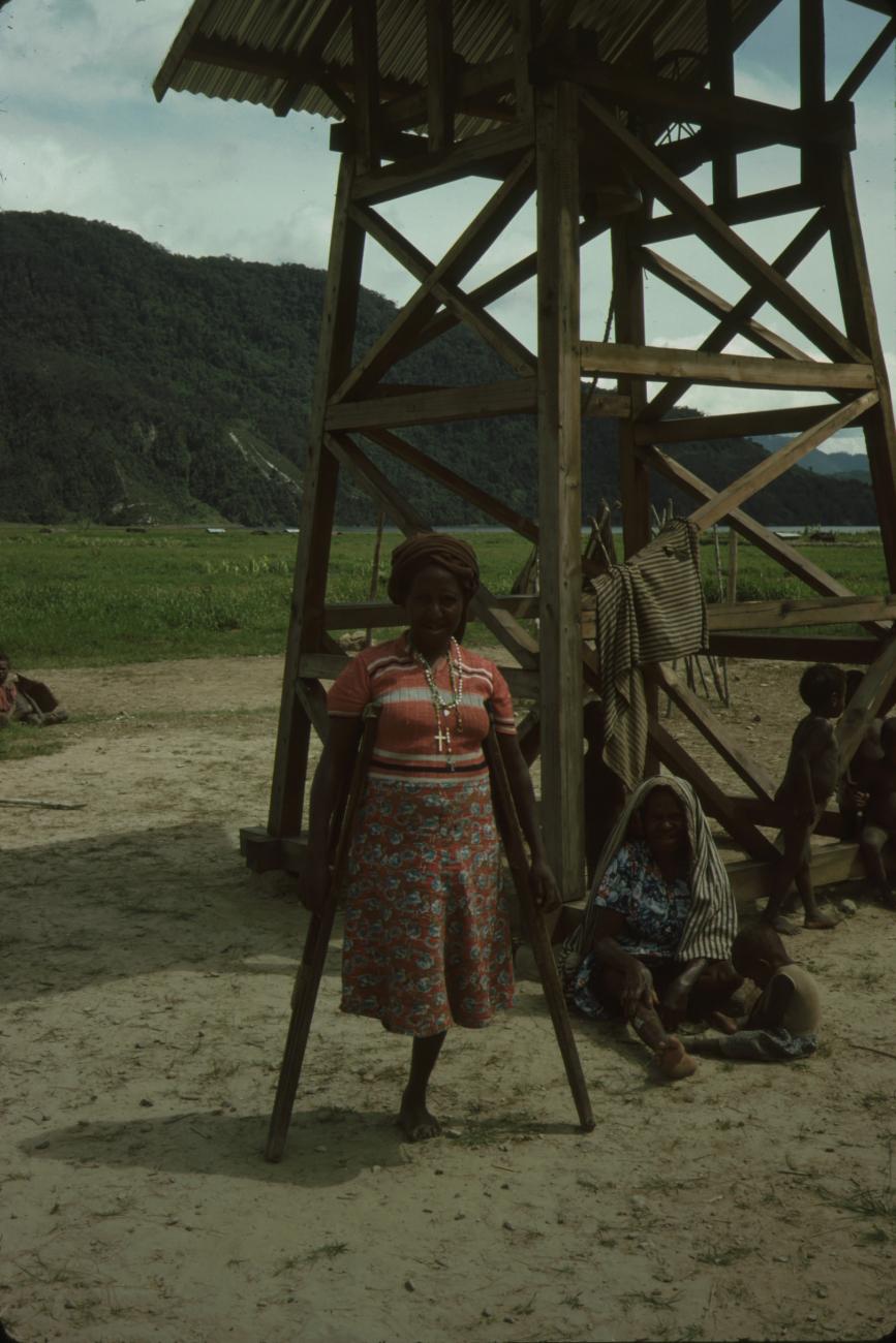 BD/132/8 - 
vrouw met een been met achtergrond huis en bergen
