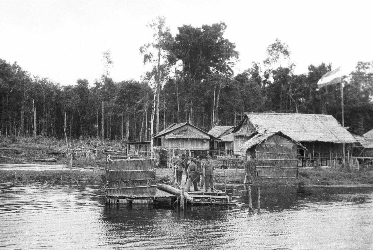 BD/133/215 - 
Een nederzetting met aanlegsteiger aan de rivier
