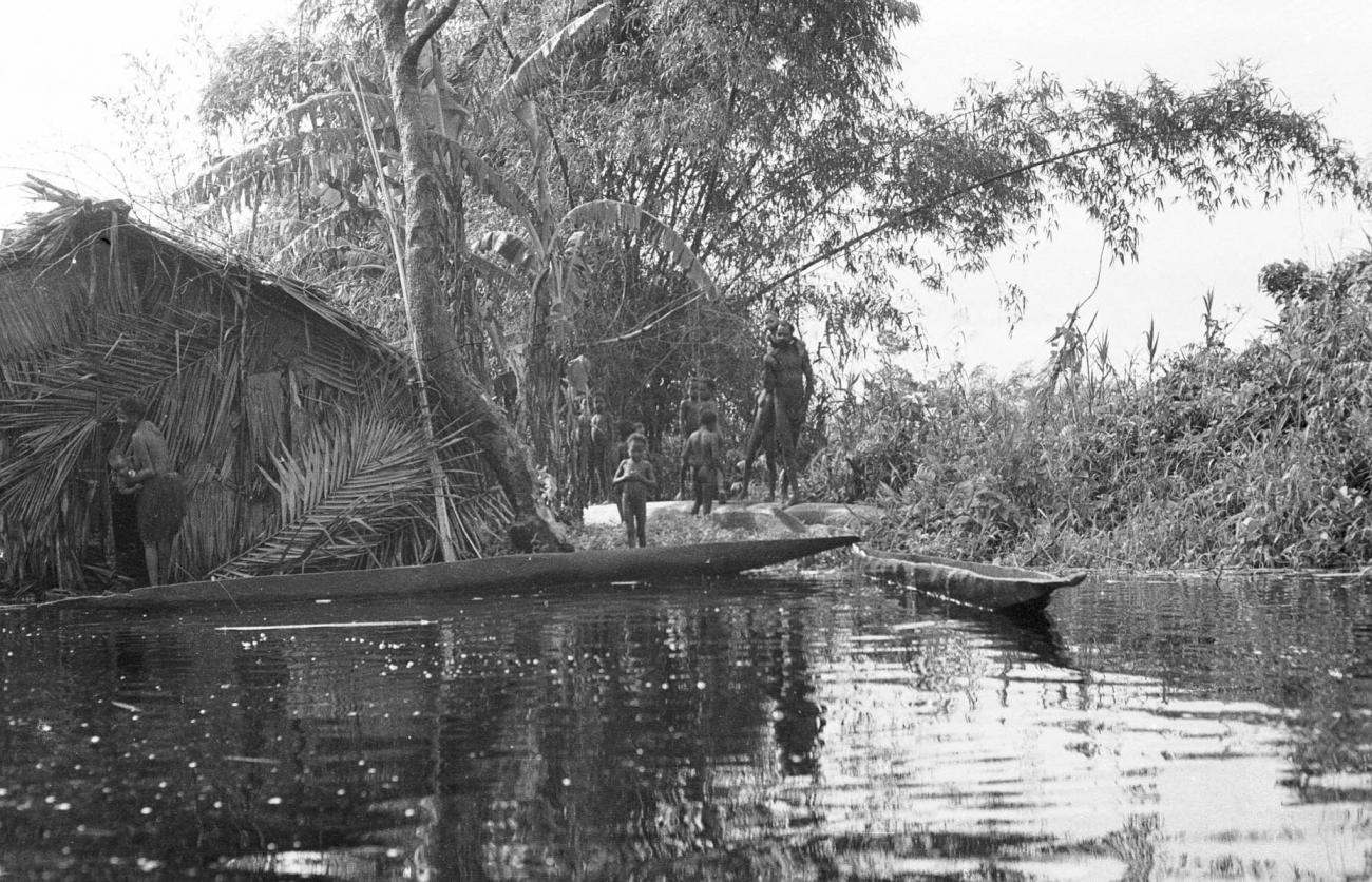 BD/133/290 - 
Tocht Merauke-Kepi-Cook: Hut met prauwen aan het water
