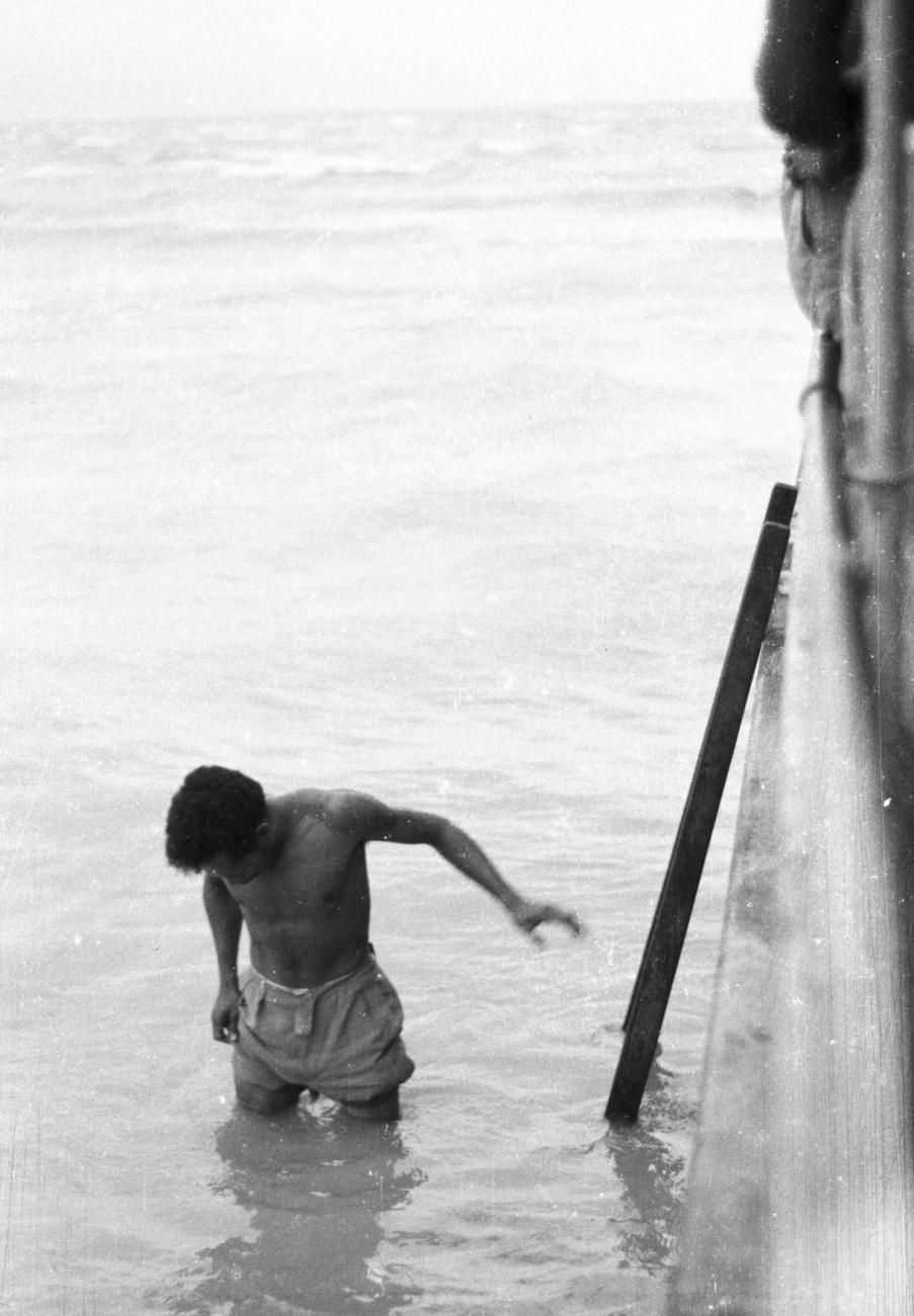 BD/133/386 - 
Man wadend door het water
