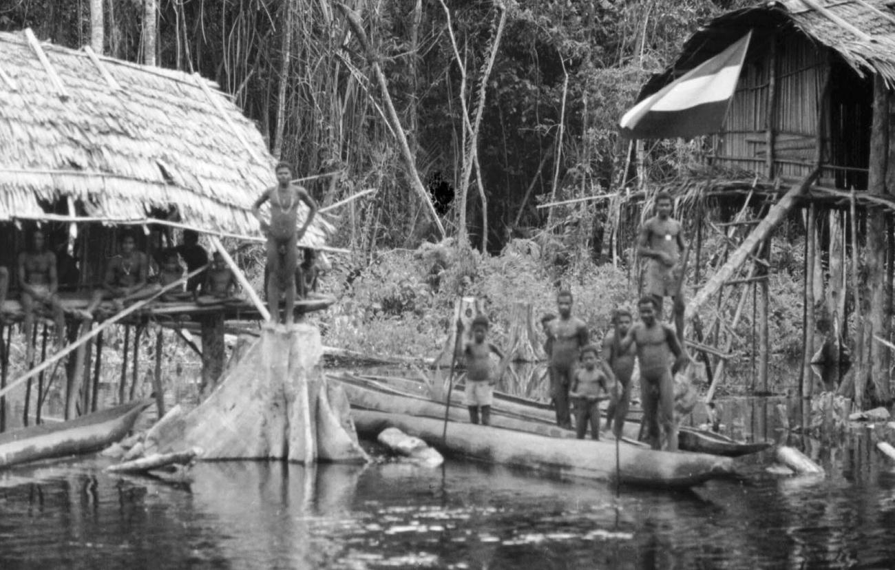 BD/133/50 - 
Tocht Merauke-Kapi: Marind-anim mensen staande in prauwen aan de oever
