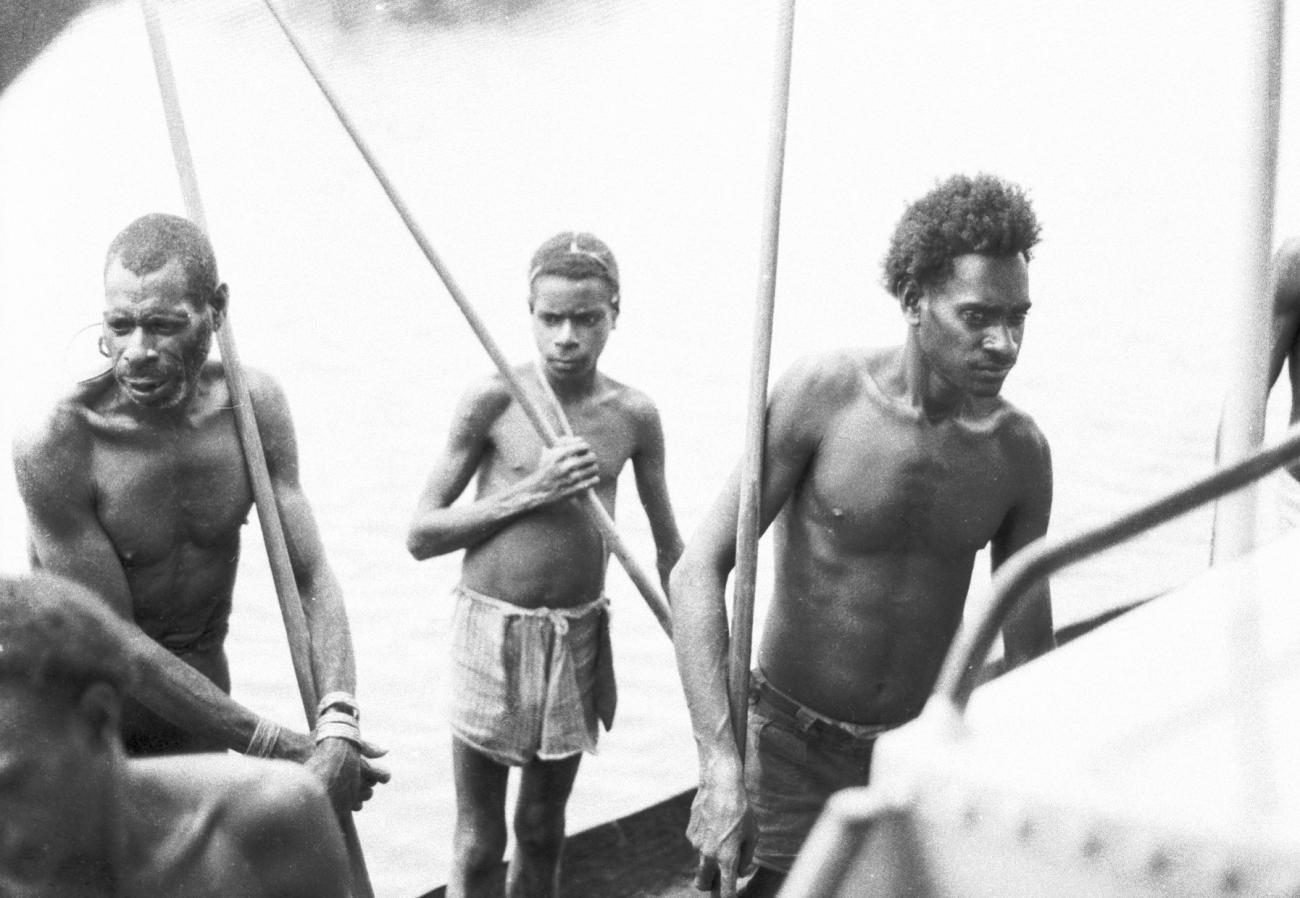 BD/133/650 - 
Portret van Papoea-mannen en Papoea-jongen, met peddels staand in prauw
