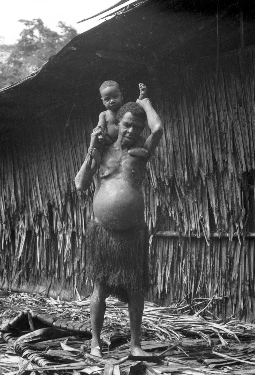 BD/133/666 - 
Portret van oudere Papoea-vrouw met kind op haar schouders
