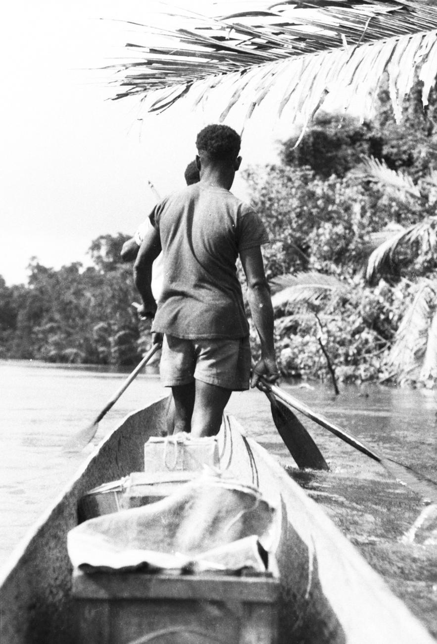 BD/133/667 - 
Papoea-mannen staand voorin prauw, achteraanzicht
