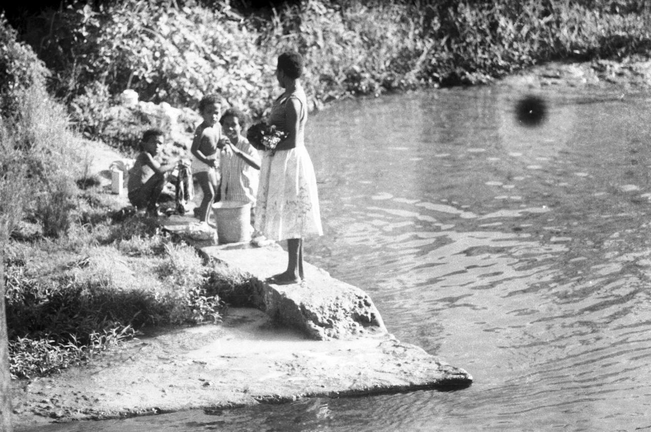 BD/133/682 - 
Paoea-vrouw en kinderen bij een wasplaats aan de rivier
