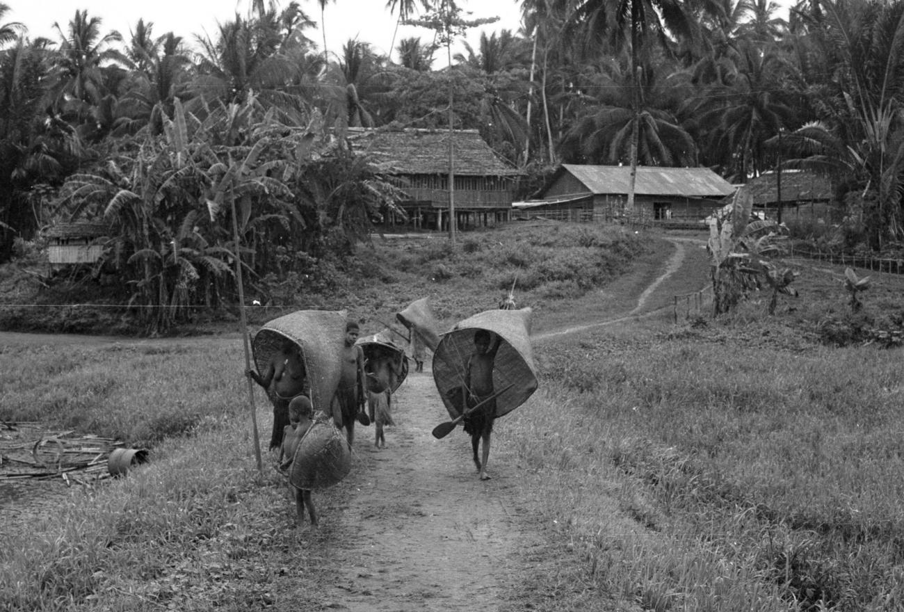 BD/133/872 - 
Groep Papoea&#039;s vanuit nederzetting op weg met visnetten 
