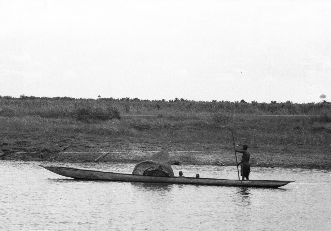 BD/133/882 - 
Papoea-vrouw met kinderen en visnet in varend in een prauw
