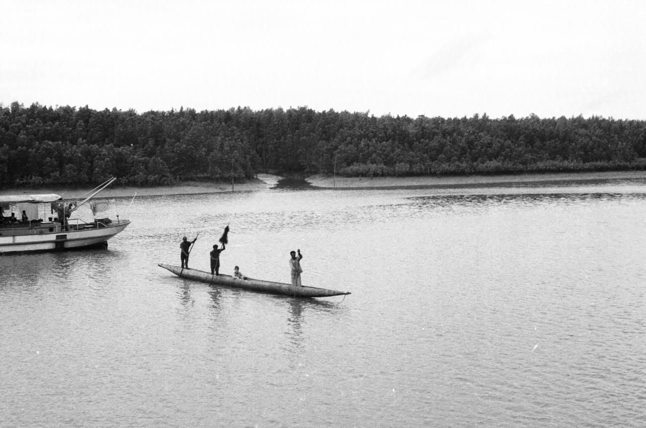 BD/133/976 - 
Papoea&#039;s met westerse passagier in prauw bij motorboot
