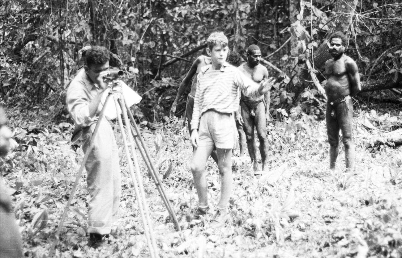 BD/133/984 - 
Landmeetkundige met westerse jongen en Papoea&#039;s (Asmat) in het oerwoud 

