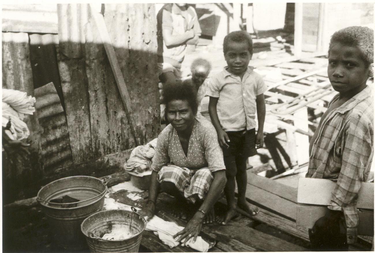 BD/253/66 - 
Vrouw en kinderen waarvan de vrouw de vloer schoonmaakt
