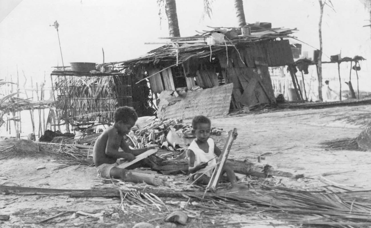 BD/277/76 - 
Twee kinderen op het strand bij een huis
