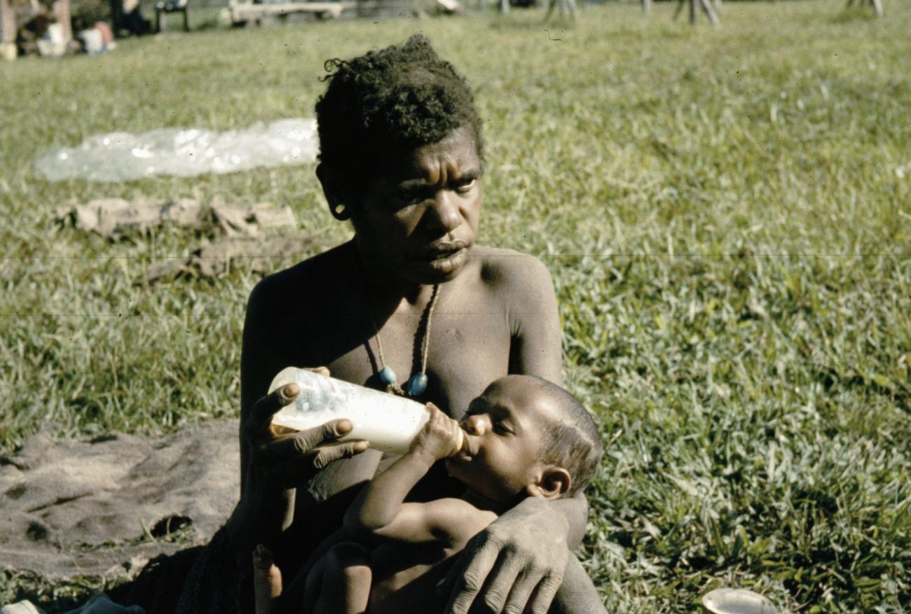 BD/285/89 - 
Vrouw geeft de melkfles aan kind 
