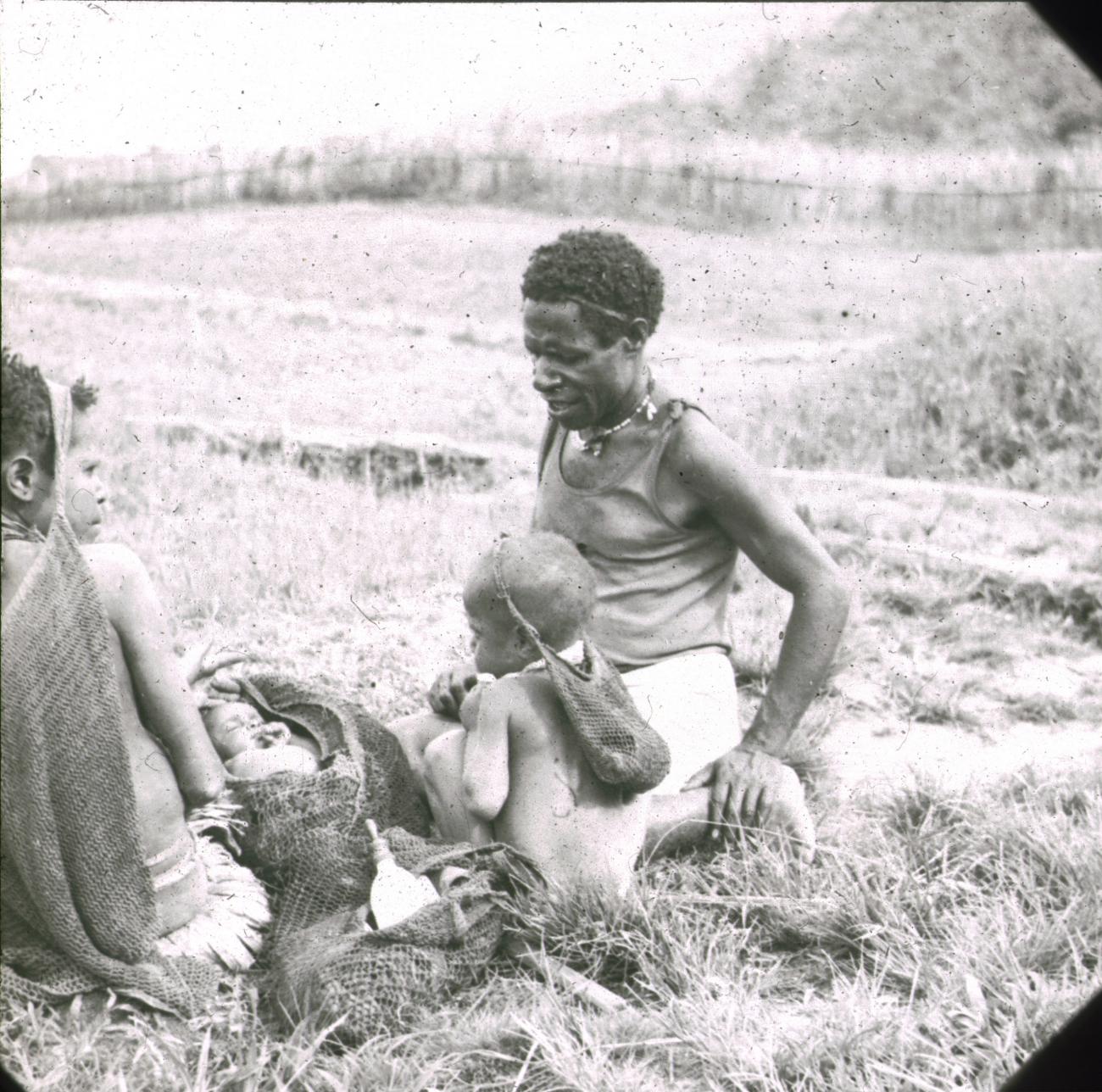 BD/329/10 - 
Papoea-vrouwen en -kind met draagnetten en baby
