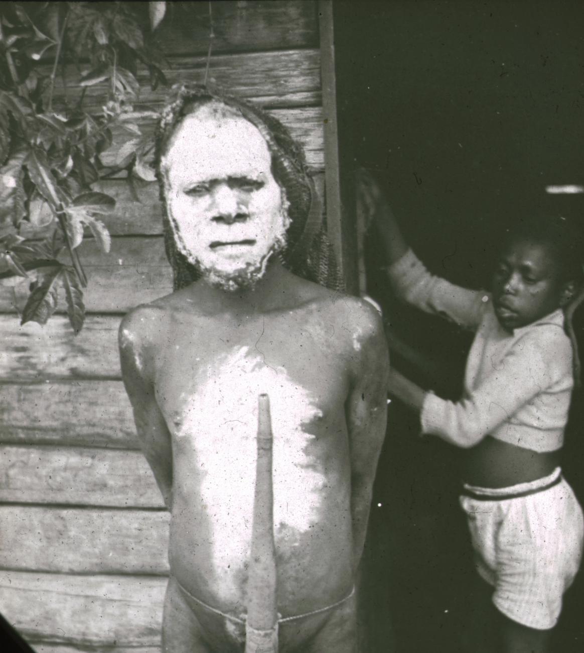 BD/329/17 - 
Portret van een Papoea-man met een peniskoker, met witbeschilderd gelaat en borst 
