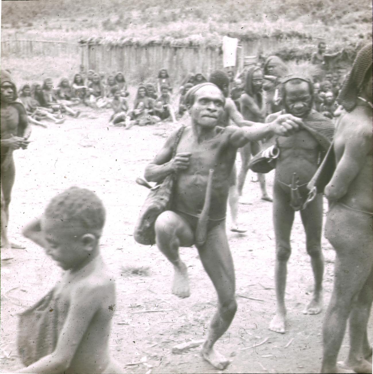 BD/329/31 - 
Dansende Papoea-man temidden van zijn stamgenoten
