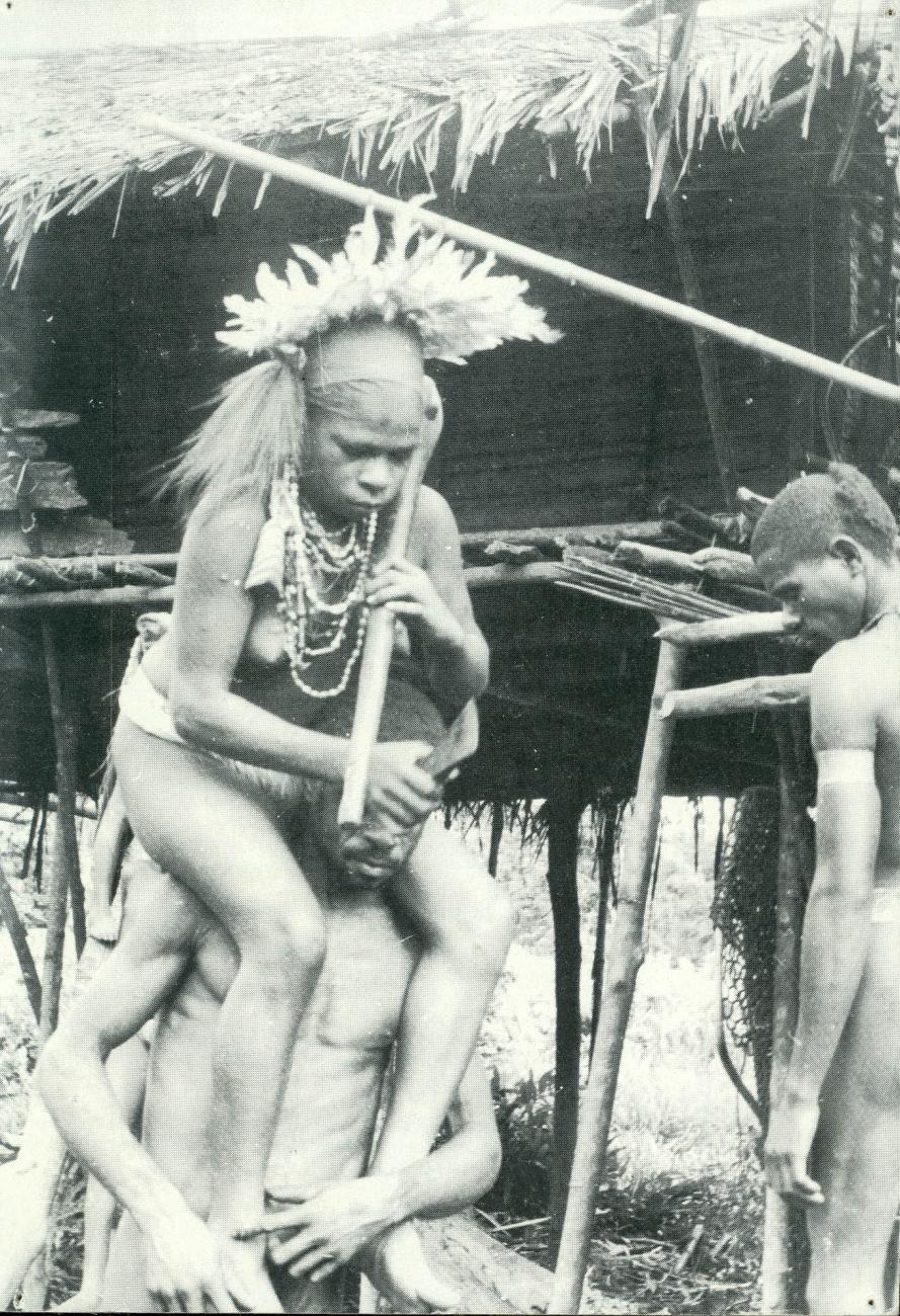BD/40/57 - 
A woman from the Asmat on a man&#039;s shoulders
