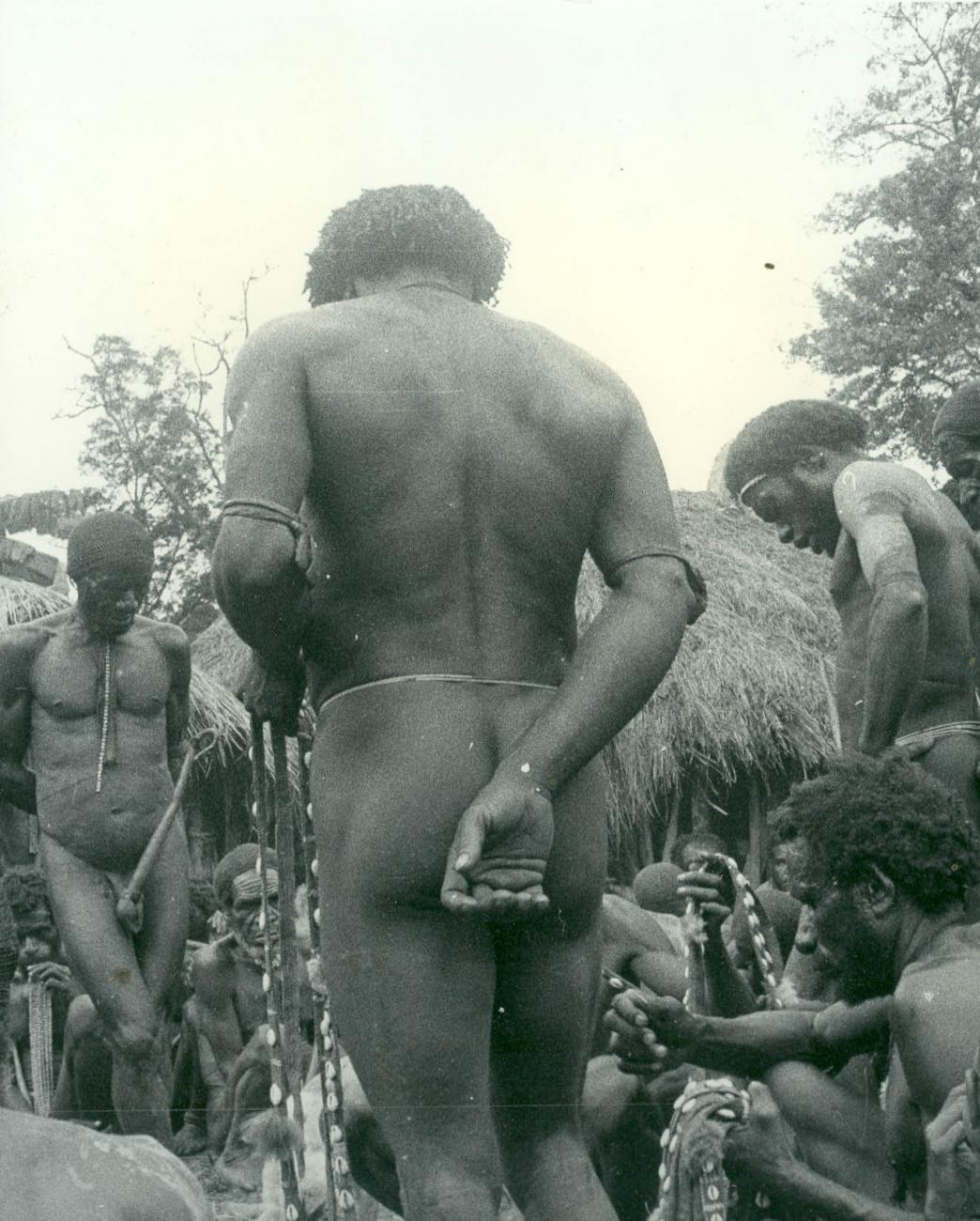 BD/40/68 - 
Berglandbewoners met peniskoker bij de inspectie van schelpenbanden

