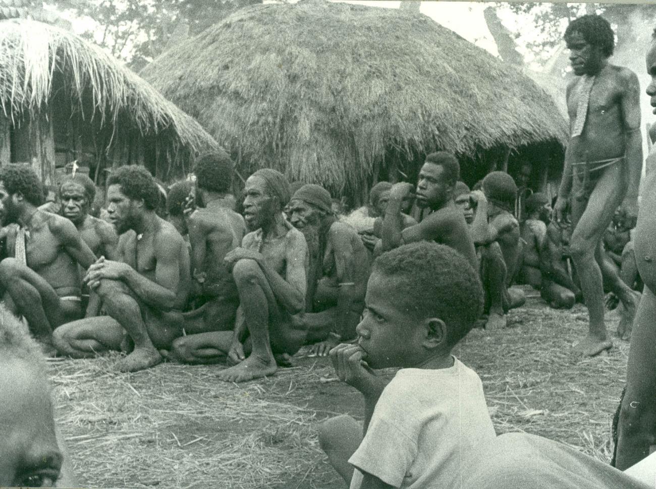 BD/40/82 - 
Sitting Mountainland inhabitants at a village
