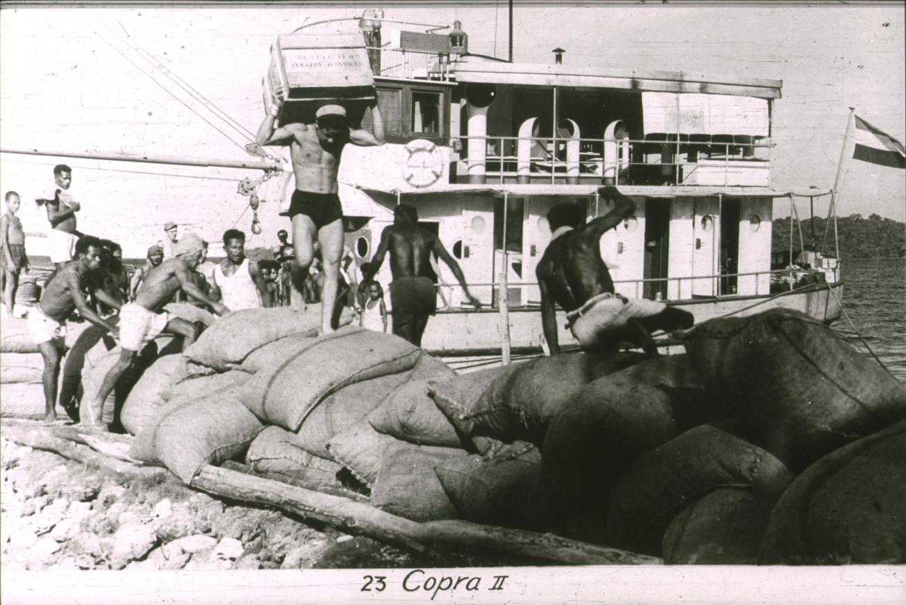 BD/186/103 - 
Mannen dragen vracht (kopra) van boot af
