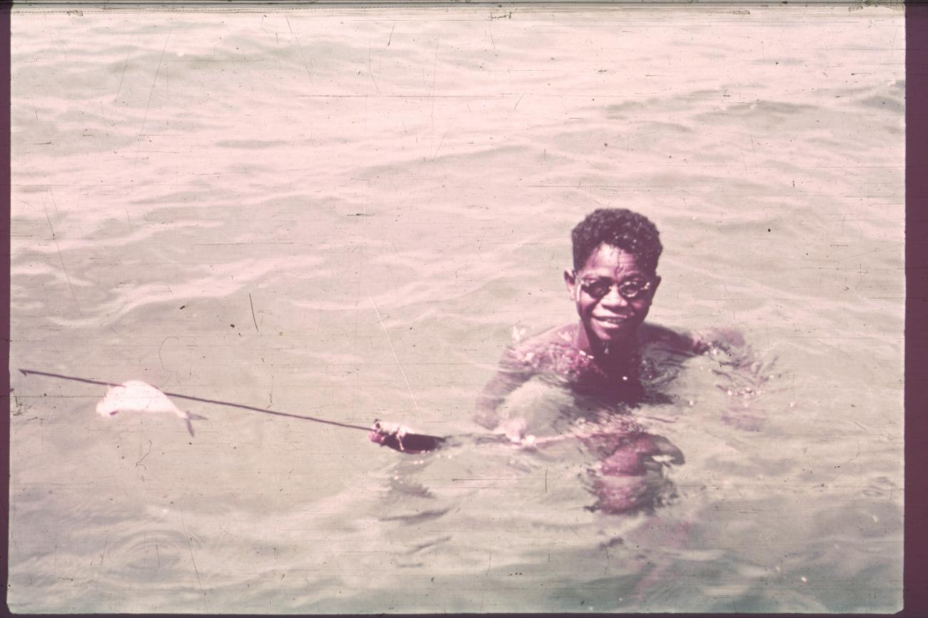 BD/186/74 - 
Jongen toont een pijl met een vis daarop gespietst
