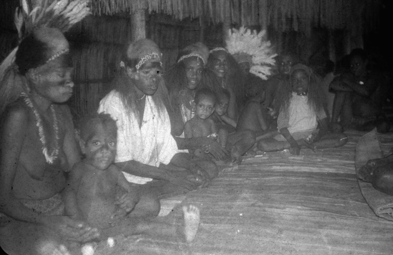 BD/216/134 - 
Vrouwen met kinderen in hut met hoofdbedekking van couscous en veren

