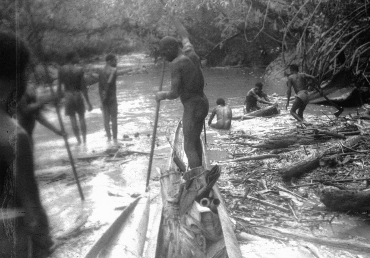 BD/216/236 - 
Mannen maken doorgang voor de prauw op ondiep deel van de rivier
