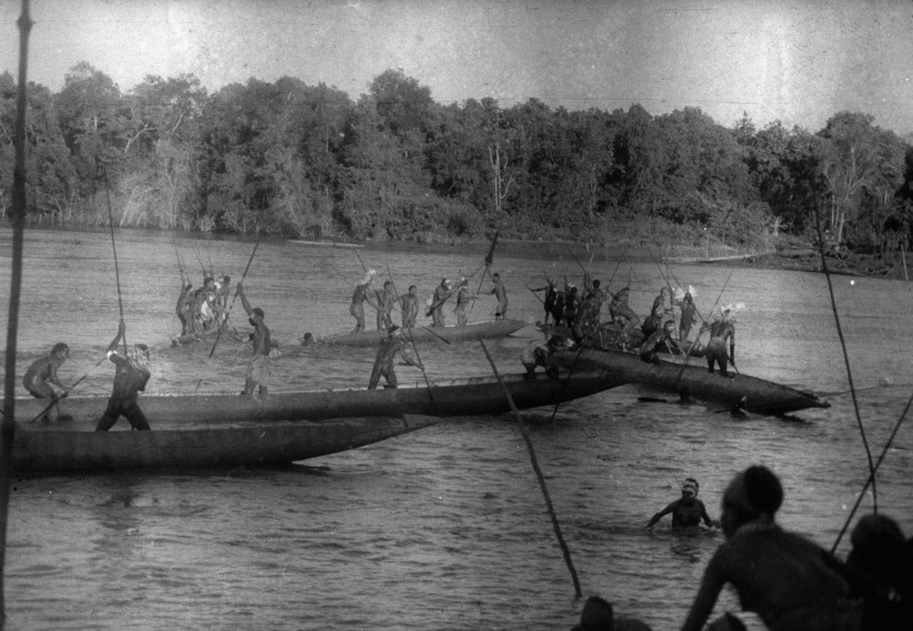 BD/216/49 - 
Mannen uit de Asmat in en op de rivier met grote prauw
