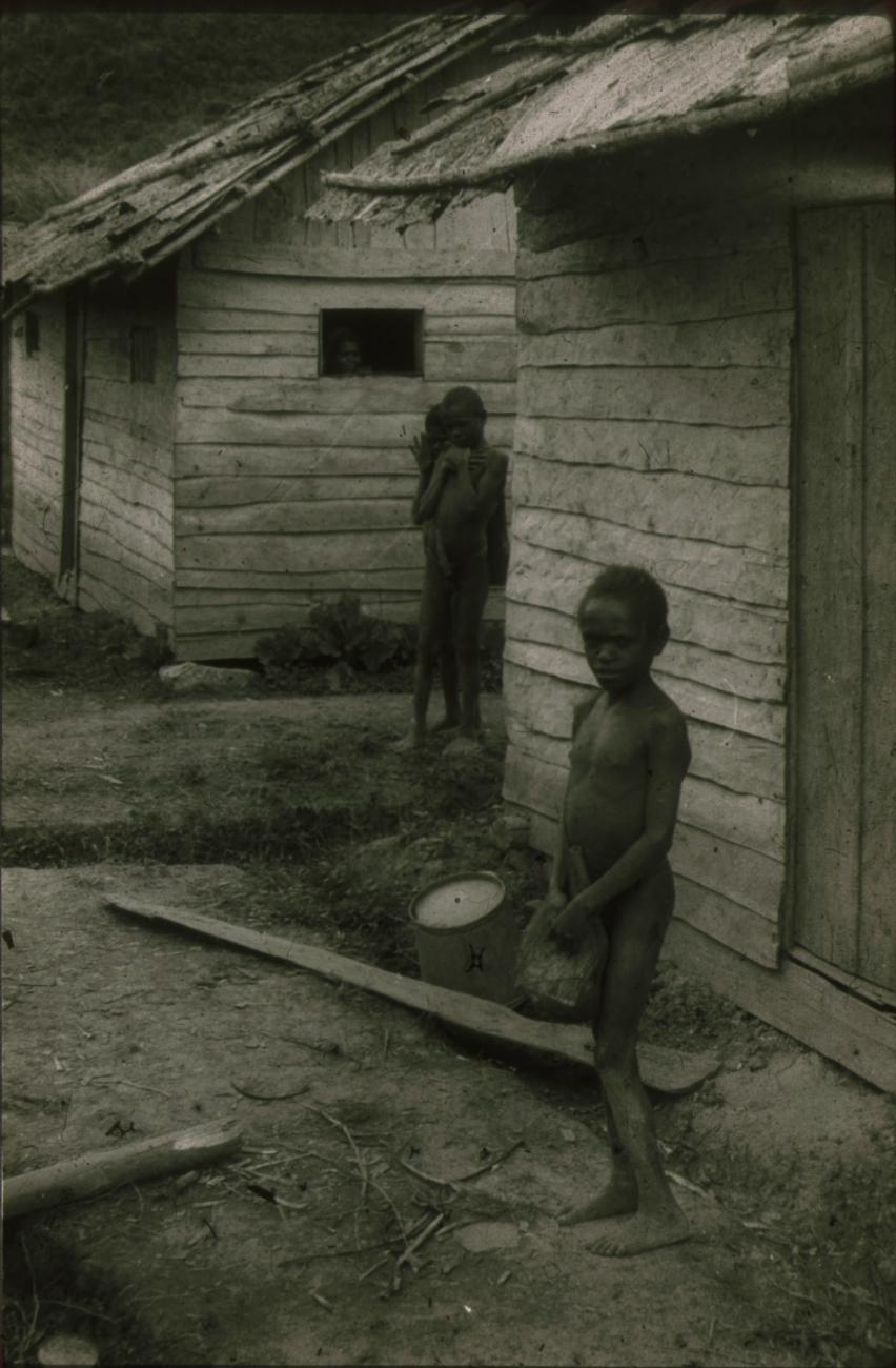 BD/248/10 - 
Kinderen tussen de houten gebouwen
