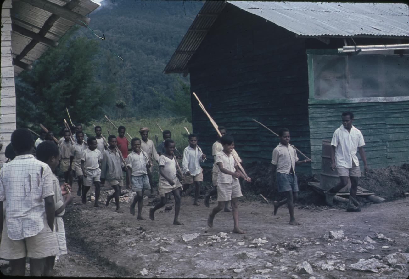 BD/248/169 - 
Aankomst van marcherende Papoea&#039;s in het dorp
