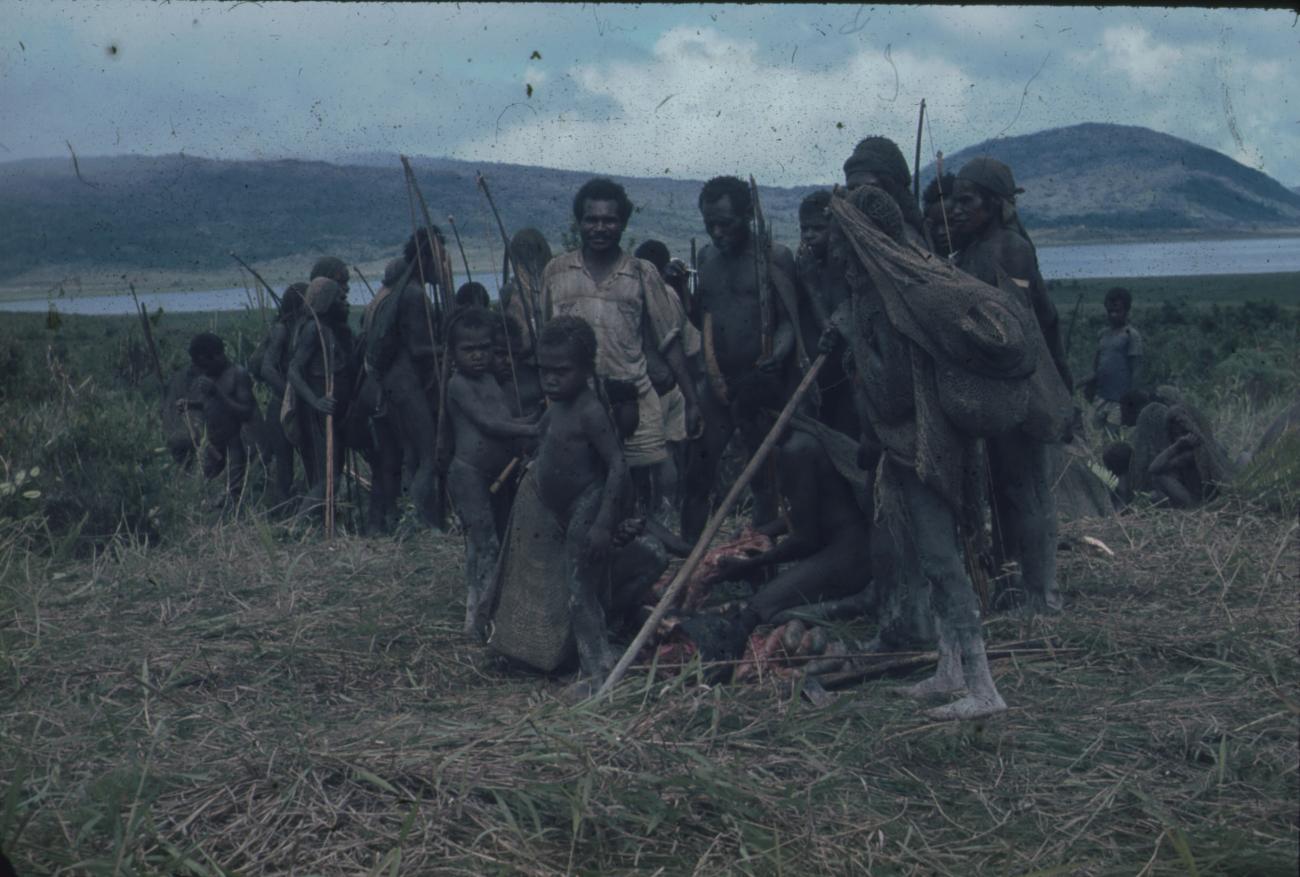 BD/248/38 - 
Zendeling met een groep Papoea&#039;s en geslacht dier
