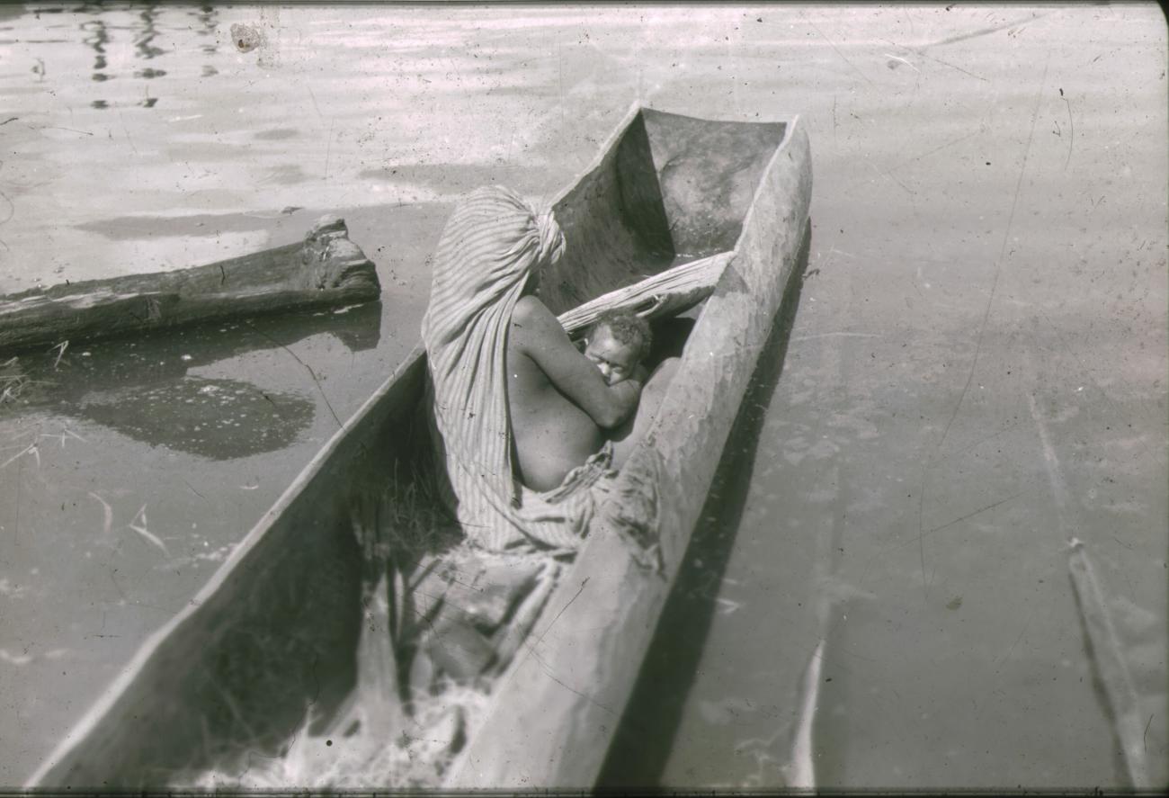 BD/248/57 - 
Vrouw met kind in een prauw op het water
