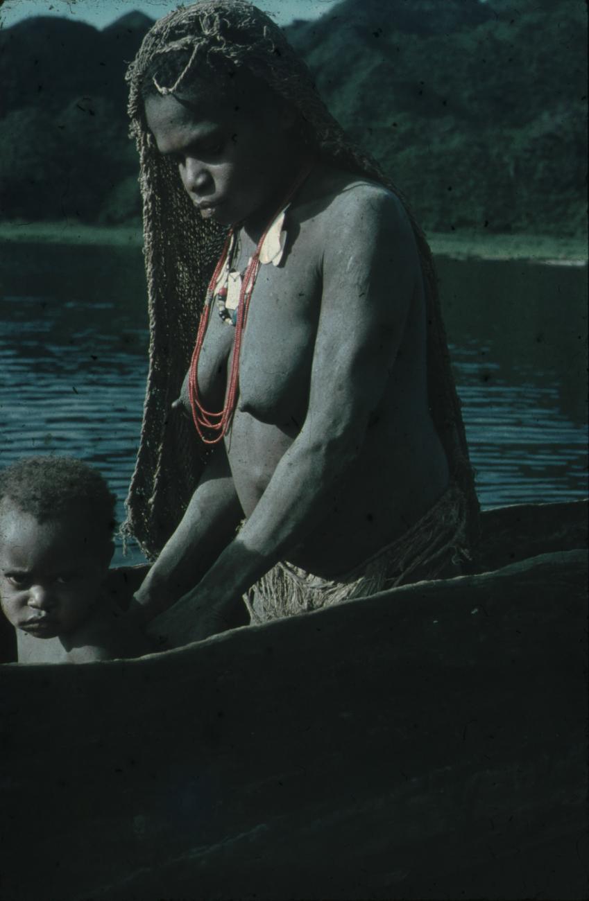 BD/248/70 - 
Vrouw met kind in een prauw op het water
