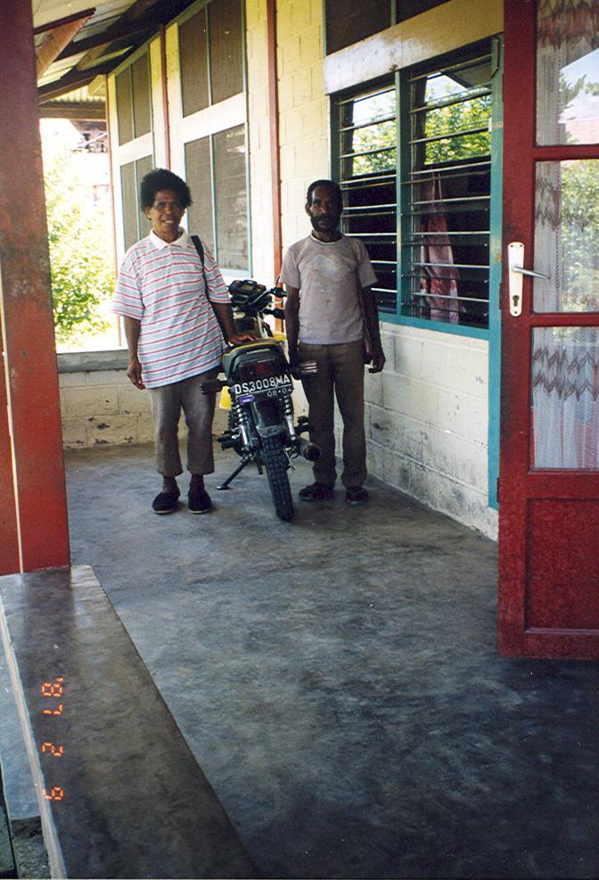 BD/269/112 - 
Papoea&#039;s poseren naast hun motor op de veranda
