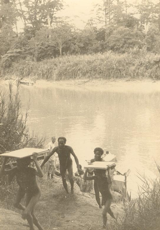 BD/269/35 - 
Papoea&#039;s dragen materiaal de rivieroever op in de Baliem?
